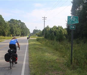 Sue and bicycle route sign, because we are on one of Adventure Cyclings routes