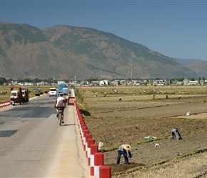 Road passes by farmers in fields