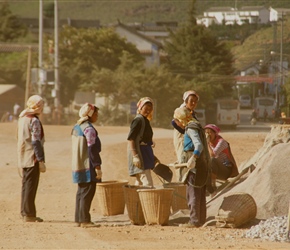 Ladies carrying baskets on the road build
