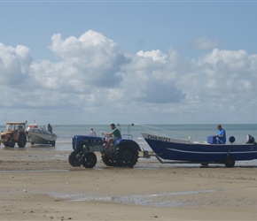 Pulling boat out of the sea at Gouville sur Mer