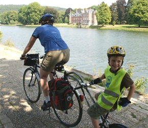 Siobhan and Jacob cycle pass John Chateau on the River Meuse